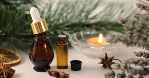 aromatherapy treatment - essential oil bottles with herbs and candle - Footage, Video