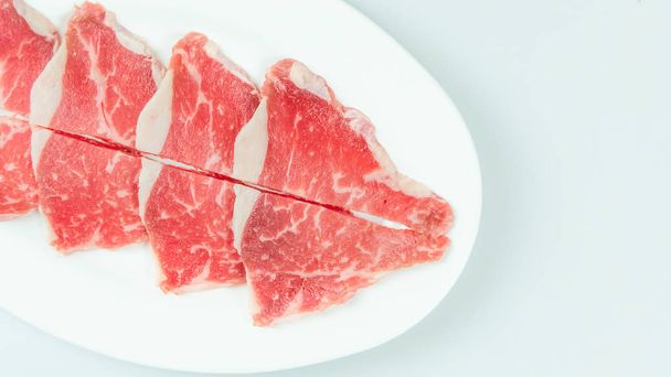 Vista superior de un poco de carne cruda en un plato sobre fondo blanco - Foto, Imagen