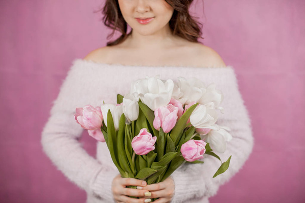Nahaufnahme junge Frau hält Strauß rosa Tulpen rosa Hintergrund Frühling - Foto, Bild