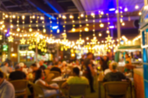 αφηρημένη θολούρα εικόνα του φεστιβάλ νύχτα σε ένα εστιατόριο και η ατμόσφαιρα είναι ευτυχισμένη και χαλαρωτική με bokeh για φόντο - Φωτογραφία, εικόνα