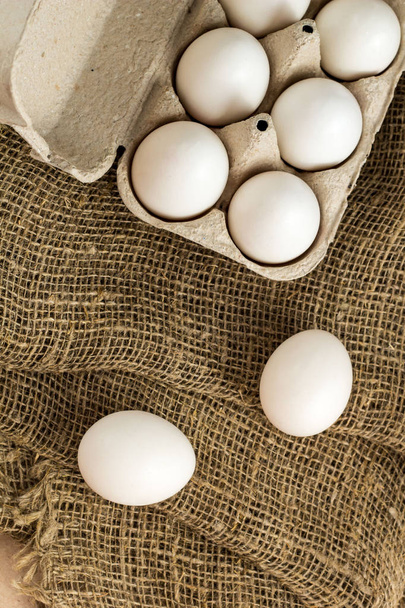 Fresh white eggs on burlap textile at rustic background with copy space. Rural still life, natural organic healthy food. - Фото, изображение