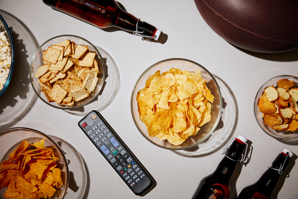 top view of glass bowl with tasty chips on white background - 写真・画像