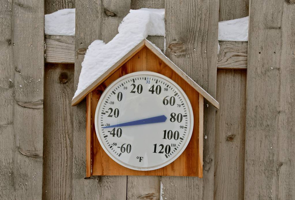 A snow covered thermometer records a frigid negative 32 degrees Fahrenheit.  - Photo, Image