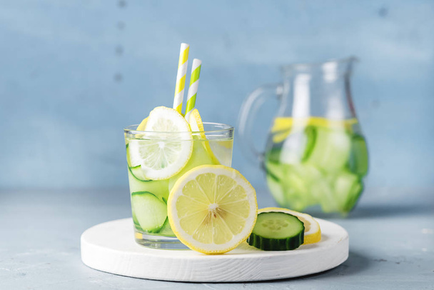 Detox Water with Cucumber and Lemon Summer Drink in Glass Jars on Blue Concrete Background Horizontal - Fotografie, Obrázek