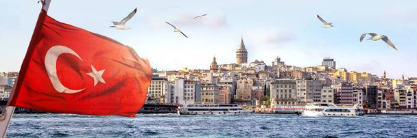 Panorama de Istambul com a Torre Galata no horizonte e gaivotas sobre o mar, ampla paisagem de Corno Dourado com a bandeira turca em primeiro plano, fundo de viagem para outdoor
 - Foto, Imagem