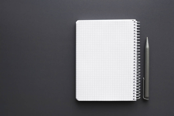 lege witte notebook met pen over grijs bureaublad - Foto, afbeelding