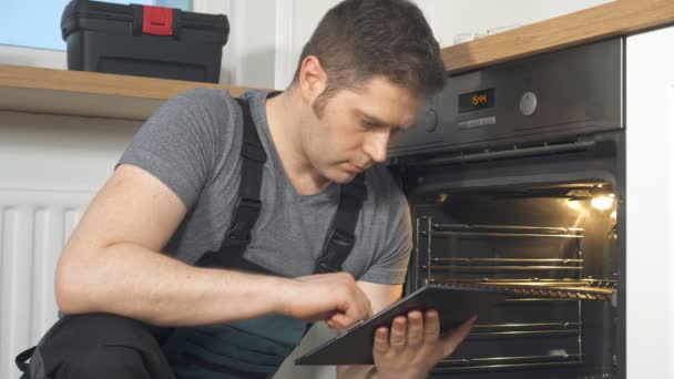 Handyman fazendo inspeção de forno doméstico na cozinha
. - Filmagem, Vídeo