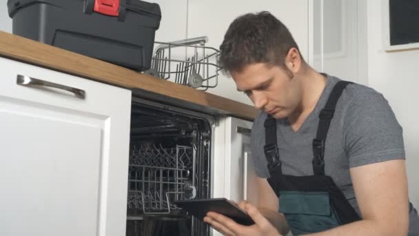 Майстер з планшетним ПК ремонт побутової посудомийної машини на кухні
. - Кадри, відео