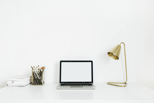 Home office desk workspace with laptop mockup and golden lamp. Minimalist modern interior design concept. Desktop table. - Φωτογραφία, εικόνα