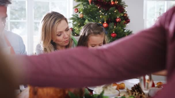 Multi-generation family sitting around table enjoying Christmas meal together - shot in slow motion - Felvétel, videó