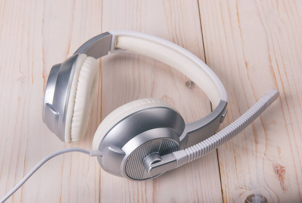 Άσπρο κομψό ακουστικά σε ανοιχτόχρωμο φόντο - Φωτογραφία, εικόνα