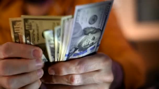El hombre casual está contando billetes de dólar americanos, cerca de las manos con dinero
 - Metraje, vídeo