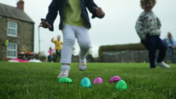 Gruppo di bambini piccoli inginocchiati in cerchio all'aperto per condividere le uova di Pasqua che hanno trovato
.  - Filmati, video
