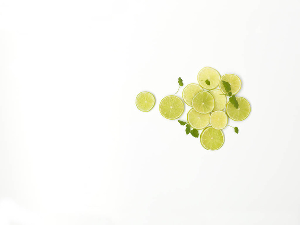 beautifully arranged fresh lime slices with mint leaves isolated on white background, close-up  - Zdjęcie, obraz