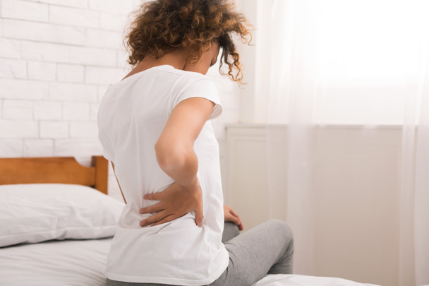 Mujer afroamericana con dolor de espalda después del sueño
 - Foto, Imagen
