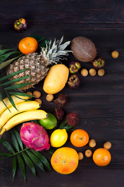 Frutos tropicais de verão maduros e suculentos na palmeira Folha em fundo de madeira. Férias estilo de vida saudável superalimentos
 - Foto, Imagem