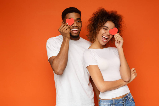 Young couple holding red love hearts over eyes - Photo, Image