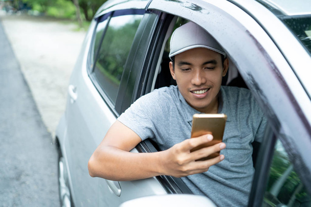 male driver use a smartphone before leaving - Foto, afbeelding