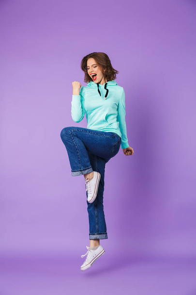 Image of an excited beautiful young woman posing isolated over purple background wall make winner gesture. - Foto, imagen