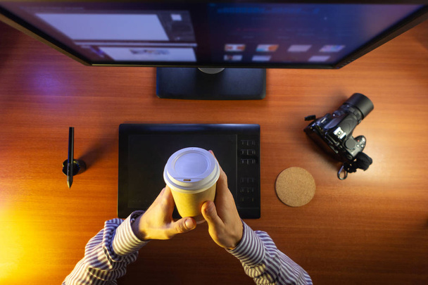 Desktop top view. Computer Graphics Tablet Camera Cup of coffee Hand Flat lay. Concept for website banner, mockup, background, presentation and marketing material - 写真・画像