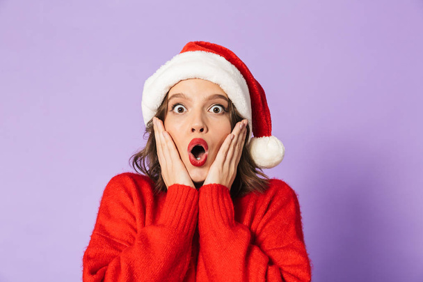 Image of an excited shocked young woman wearing christmas hat isolated over purple background. - Φωτογραφία, εικόνα