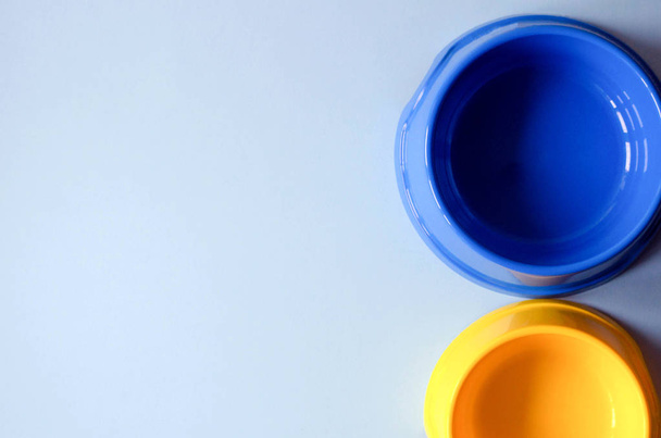 Dvě prázdné misky modré a žluté pro potraviny a domácí vodu. - Fotografie, Obrázek