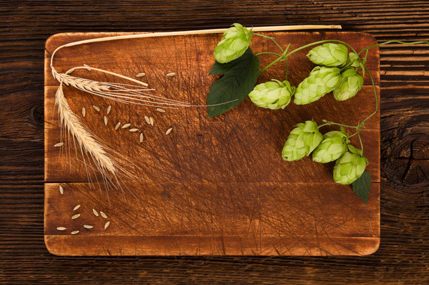 Verse hop met gerstekorrel en bladeren op houten ondergrond met copyspace. Bier productie ingrediënt. Brouwerij. Hop, vers geplukt. - Foto, afbeelding