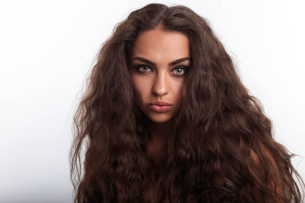 Model with hair like lion mane. Portrait of pretty young woman with long curly wavy brown hair. Funny face. - Fotografie, Obrázek