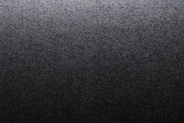 Nahaufnahme von schwarzem, rauem Hintergrund, beleuchtet mit gedämpftem Licht. - Foto, Bild