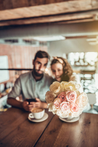 Hermosa pareja pasa tiempo en cafe.Surprise para su esposa flores de ramo
. - Foto, Imagen