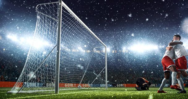 Momento de fútbol intenso frente al gol en el estadio de fútbol profesional mientras nieva. Estadio y multitud se hacen en 3D
. - Foto, Imagen