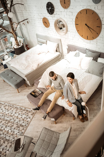 Joyful active couple checking softness of presented mattress - Zdjęcie, obraz