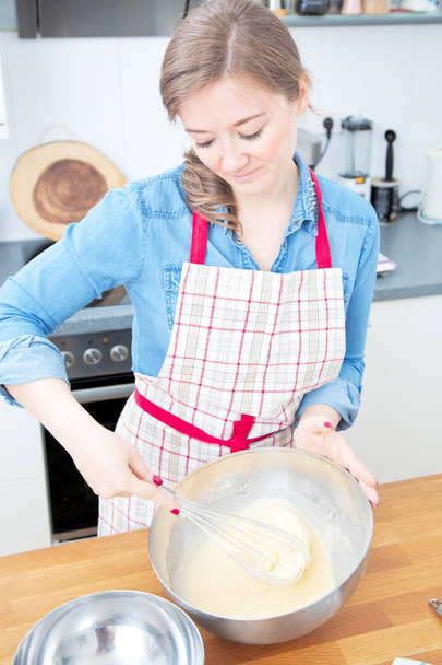 high angle view of beautiful young woman in apron preparing dough in kitchen - Foto, Imagem