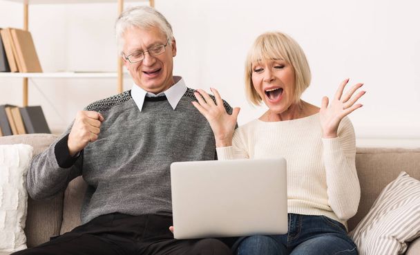 Podekscytowany starszy para świętuje zwycięstwo, wygrywając online na przetargu - Zdjęcie, obraz