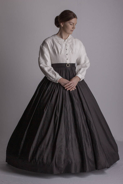 白ブラウスと黒スカートのビクトリア朝の女性 - 写真・画像