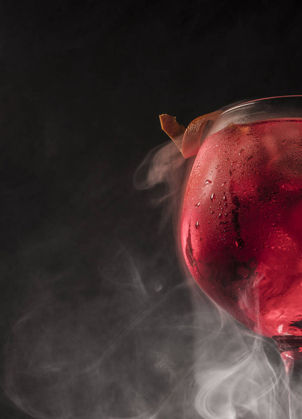 Cup of gin and tonic wet with smoke and dark background. - Photo, Image