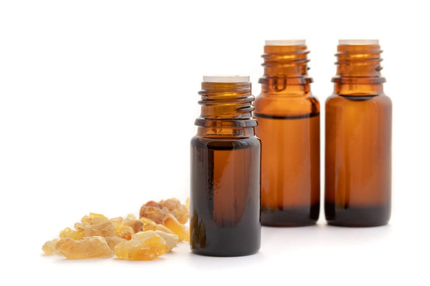 Bottles of essential oil with frankincense resin on a white background - Fotó, kép