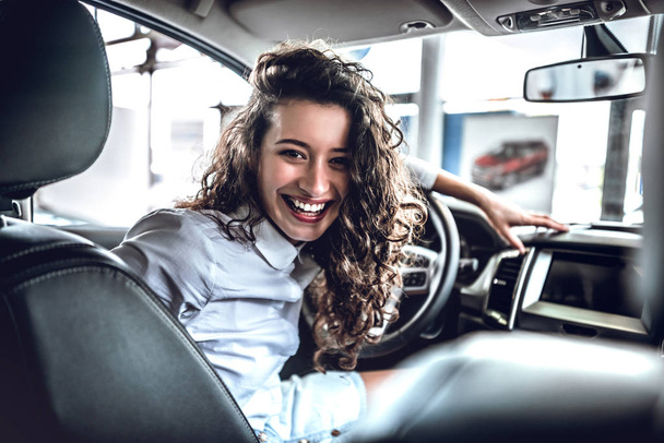 Portrait of beautiful happy young woman inside in new car. - Photo, Image