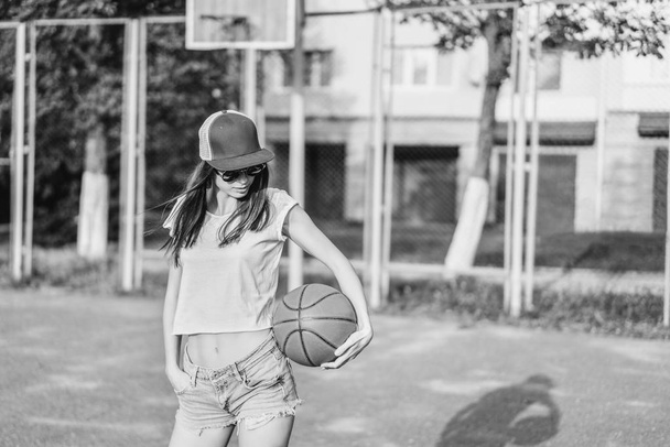 Pretty young sporty girl with basketball ball outdoor - Photo, Image
