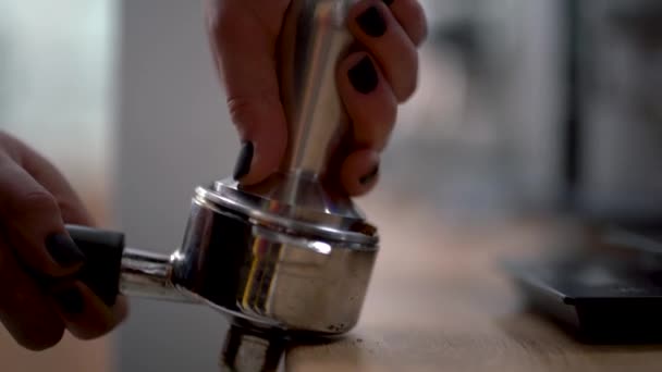 Woman or barista presses the ground coffee in the holder to make a delicious coffee and going to switch on coffee machine - Materiał filmowy, wideo