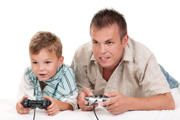 Vader en zoon Joysticks en videospelletjes spelen op console bij elkaar te houden. Gelukkige familie - vader en jongetje met plezier gaming op witte achtergrond. Man met kind spelen van computerspel. - Foto, afbeelding
