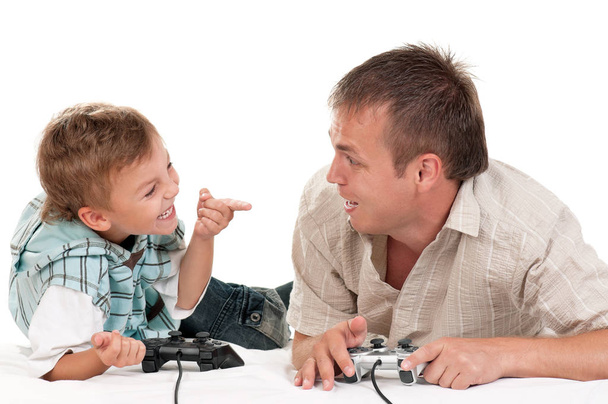 Папа и сын держат Joysticks и играют в видеоигры на консоли вместе. Счастливая семья - отец и маленький мальчик весело играть на белом фоне. Человек с ребенком, играющий в игру
. - Фото, изображение
