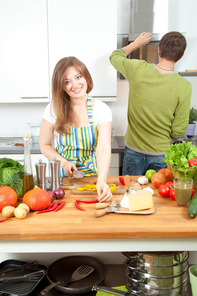 Jovem casal feliz preparando comida saudável juntos na cozinha. Conceito de alimentação saudável
 - Foto, Imagem