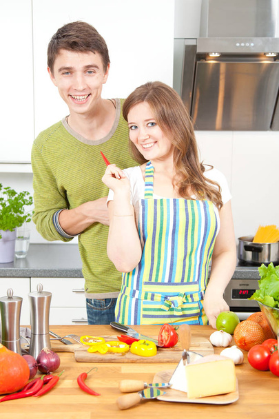 Happy young couple preparing healthy food together in kitchen. Healthy food concept - Photo, Image