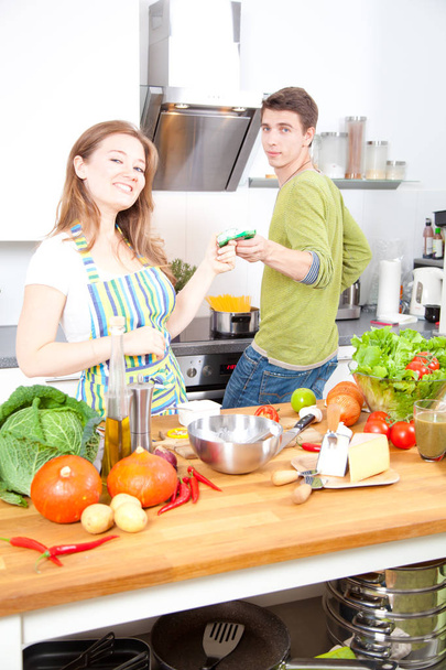 Onnellinen nuori pari ruoanlaitto keittiössä yhdessä
 - Valokuva, kuva