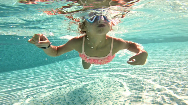 Μικρό κορίτσι που φοράει ψαροντούφεκο μάσκα υποβρύχιο κολύμπι στην πισίνα. - Πλάνα, βίντεο