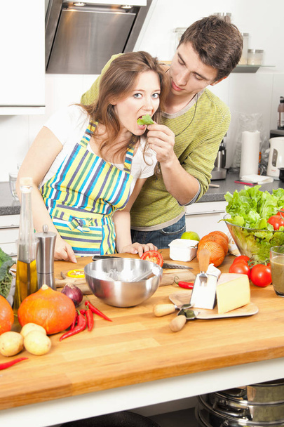 Heureux jeune couple cuisiner ensemble à la cuisine
 - Photo, image