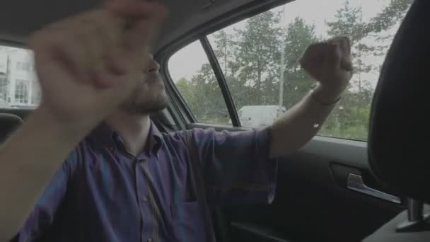 Joyful teen man dancing inside travel car happy to going on road trip holiday - Кадры, видео
