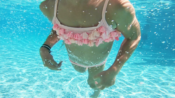 Bambina che indossa maschera di snorkeling nuotare sott'acqua in piscina
. - Filmati, video