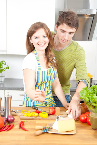 Счастливая молодая пара готовит на кухне вместе
 - Фото, изображение